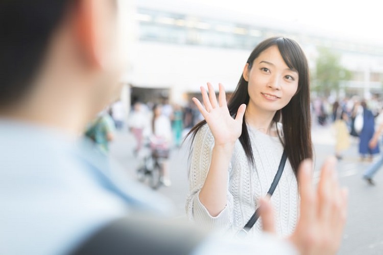 女性に手を振る男性