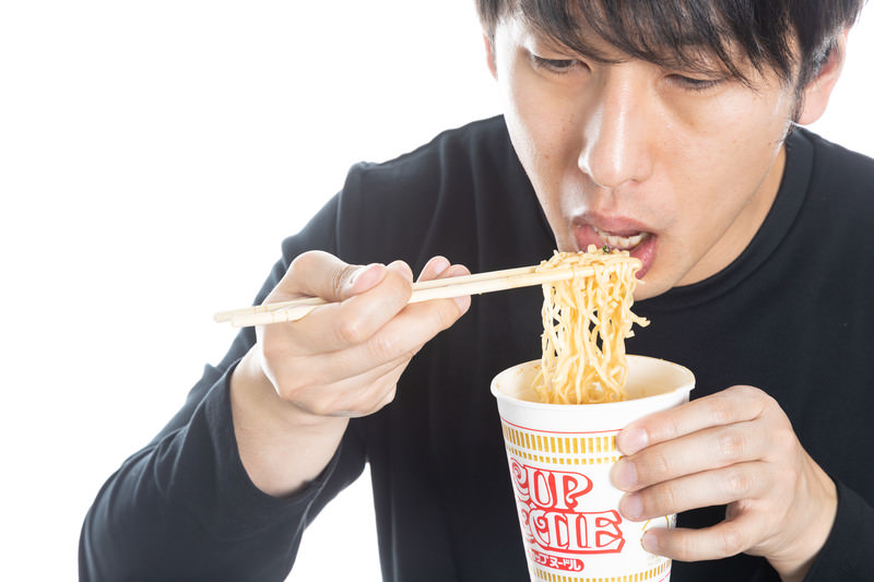 カップ麺を食べる男性